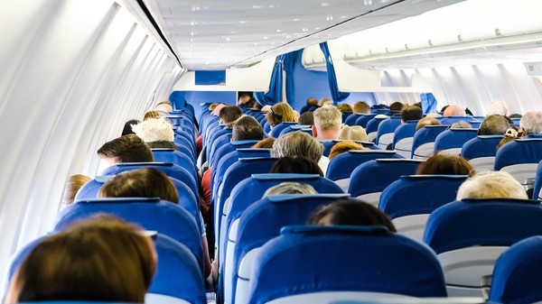 Imagine din interiorul unui avion cu scaunele pline de oameni