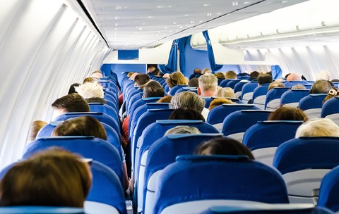 Imagine din interiorul unui avion cu scaunele pline de oameni