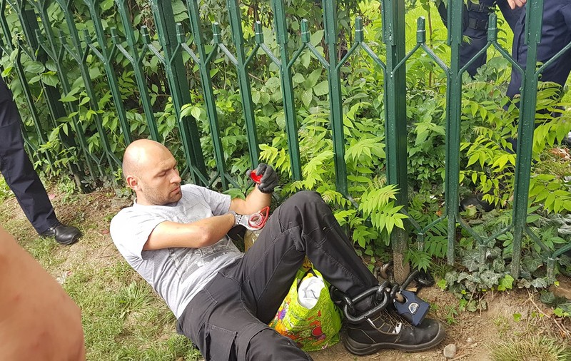 UPDATE. Bărbatul care s-a legat cu lanțul de gardul Guvernului și avea asupra lui o sticlă de benzină a fost descarcerat si ridicat de Jandarmerie (FOTO / VIDEO)