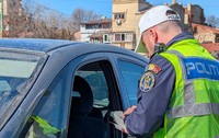 Un polițist verifică actele unui șofer dintr-o mașină neagră