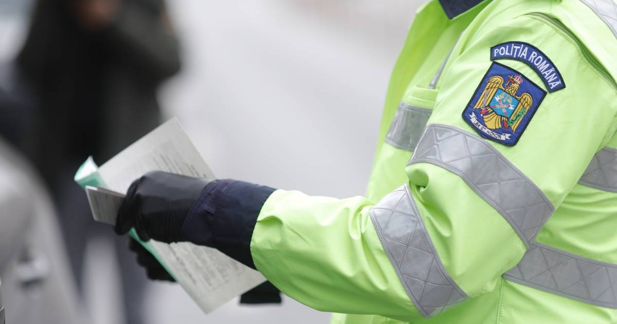Un ofițer de poliție rutieră român oprește o mașină pentru a verifica actele de identitate ale șoferului. Conceptul de amenda rutieră
