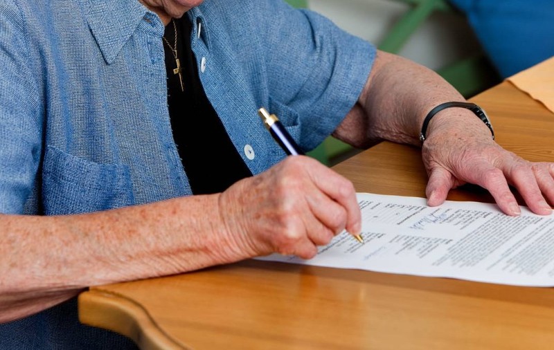 femeie pensionară semneaza contract