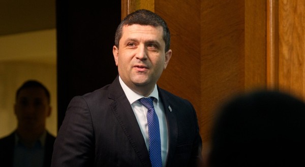 Radu Miruță în costum negru în timp ce zâmbește