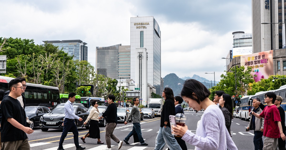 Oameni trec strada pe la trecerea de pietoni in Seul, Coreea de Sud