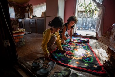 Cele două fetiţe deretică prin casă, înainte de sosirea bunicii