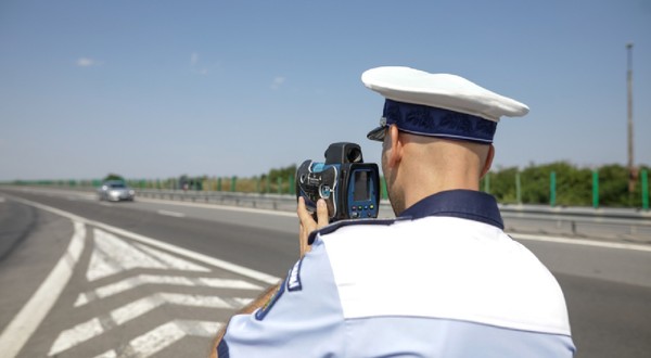 Autostrada 2 București - Constanța, România - 10 august 2021: Un agent al Poliției Rutiere din România folosește un radar de viteză.