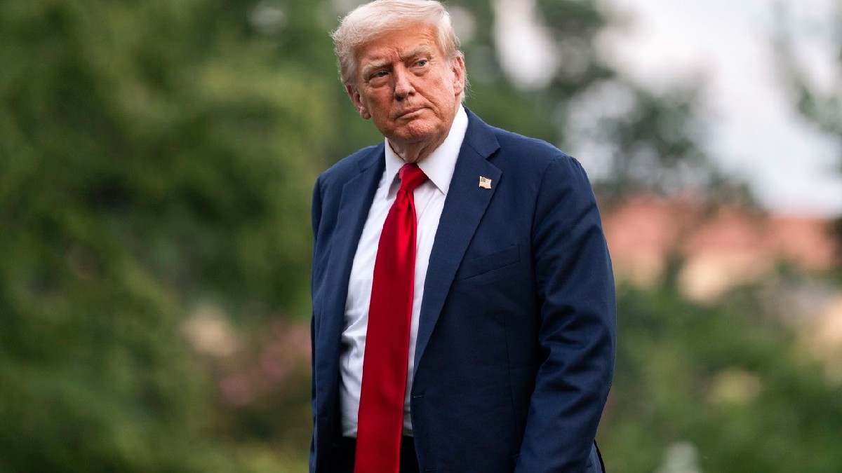 Donald Trump, îmbrăcat în costum albastru cu o cravată roșie și o cămașă albă