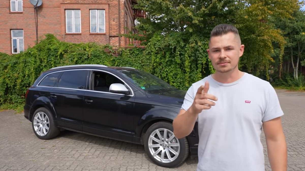 Un bărbat se află în fața unui Audi Q7, într-o parcare