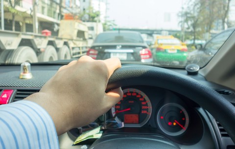 Un bărbat care stă la volanul mașinii, în timp ce este oprit la semafor
