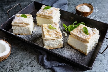Delicious puff pastry cream cake dessert filled with vanilla and coconut custard, dusted with powdered sugar