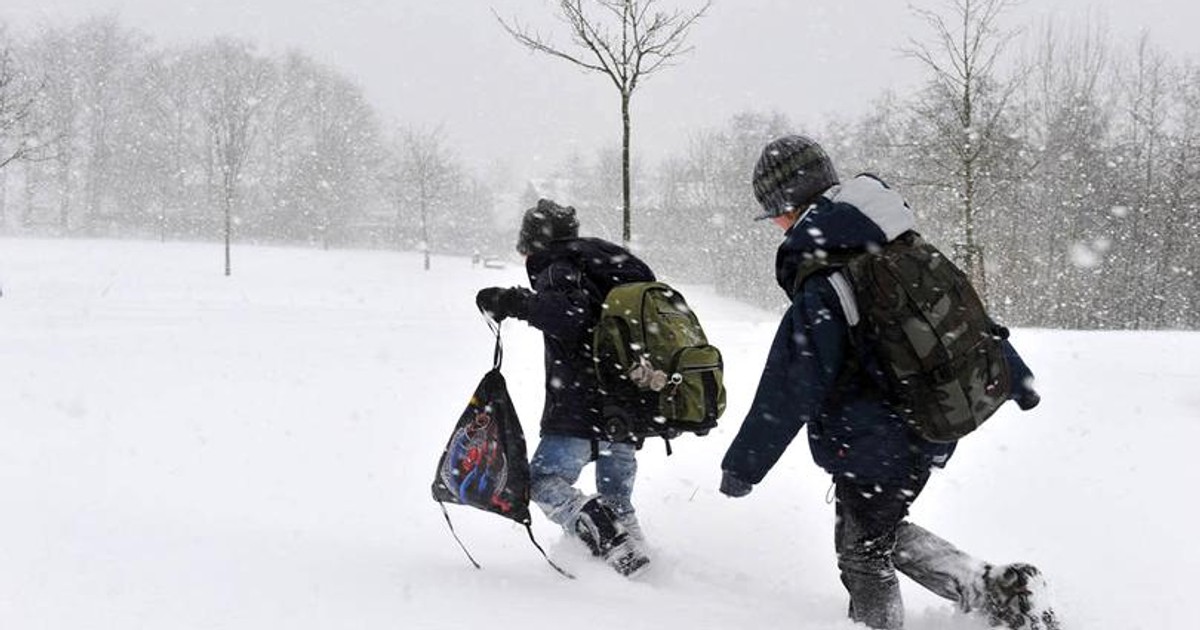 Primele ninsori în România, din iarna lui 2018. Elevi mergând prin viscol, cu ghiozdanele în spate