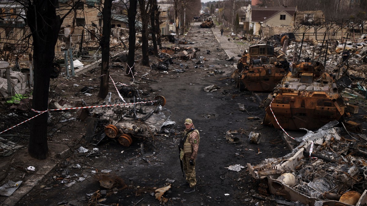Un militar ucrainean stă în mijlocul tancurilor rusești distruse în Bucha, 4 aprilie 2022. Foto: Profimedia