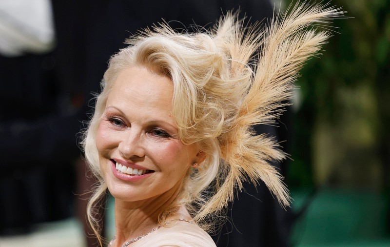 Pamela Anderson, diva de la Met Gala 2024. A încercat să respecte codul vestimentar și și-a înfrumusețat cocul cu pene