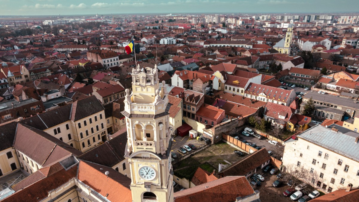 Clădiri văzute de sus, un turn cu ceas cu un steag