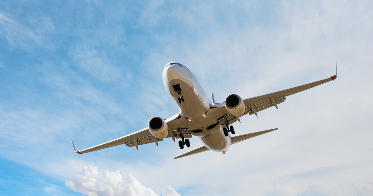 Un avion aflat în timpul zborului. În fundal, cerul este senin.