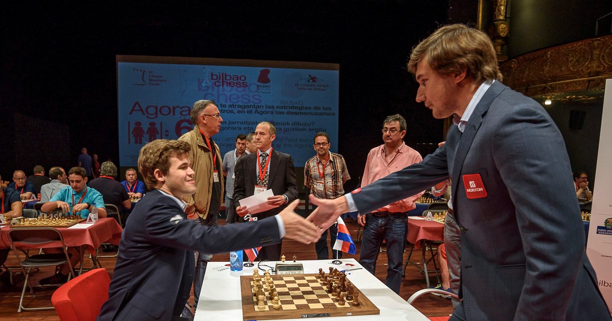 Magnus Carlsen (stânga) îi strânge mâna lui Serghei Kariakin la finalul unei partide de șah. (FOTO: EPA)