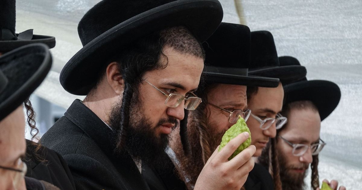 Israelieni din comunitatea Haredi aliniați. Toți au pălării negre în cap