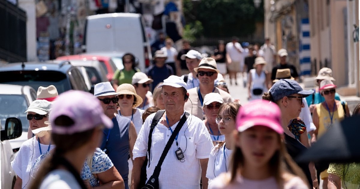 Un grup de turiști poartă pălării în centrul Atenei, Grecia, pe 16 iulie 2025. Vizitatorii explorează orașul sub soarele arzător.