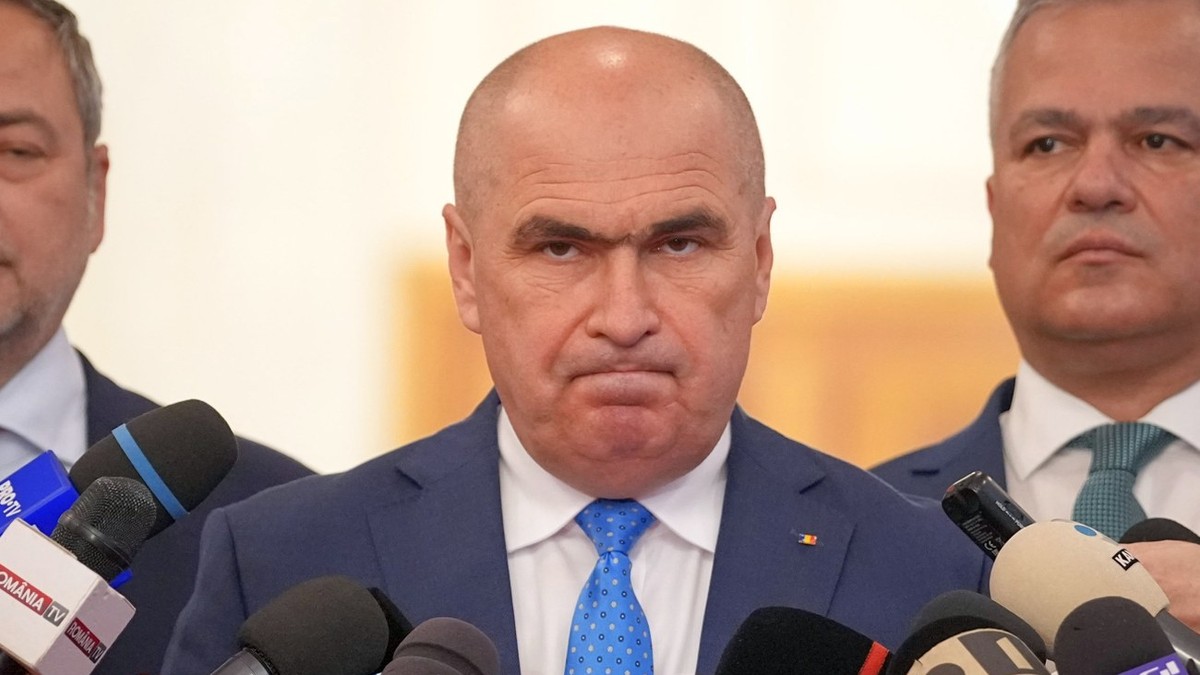 Ilie Bolojan privește fix în camera foto, cu buzele strânse, având o atitudine necruțătoare