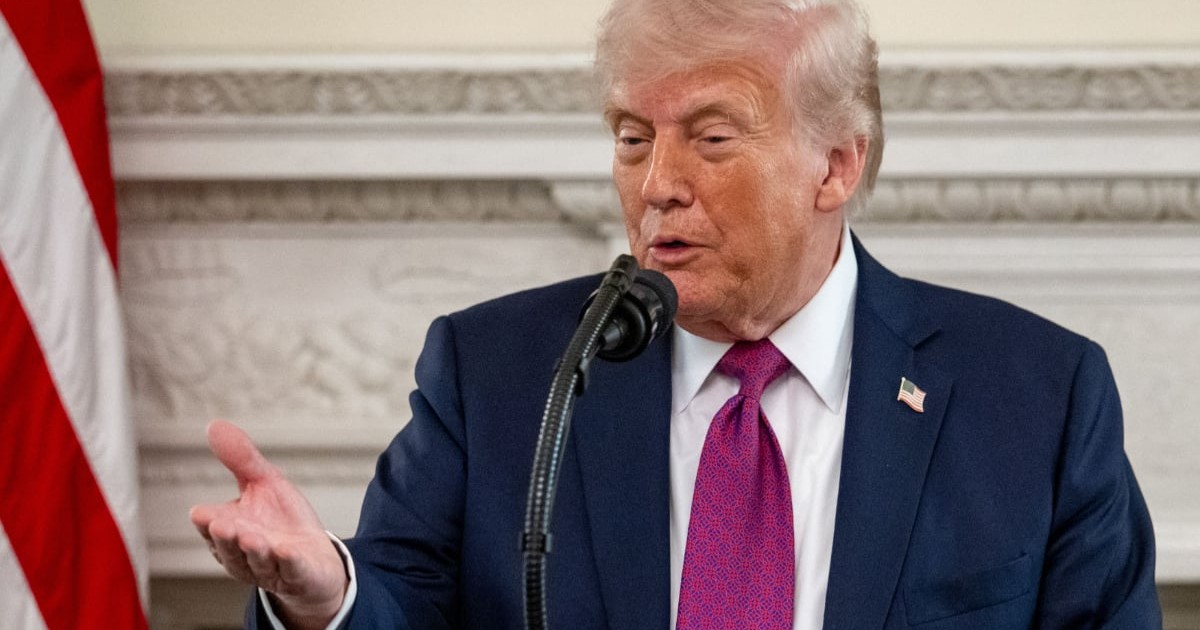 Președintele american Donald Trump, în timpul unei conferințe de presă la Casa Albă, poartă un costum albastru și o cravată mov și gesticulează