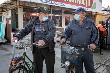 Doi bărbaţi din Malu ies din curtea unui magazin de construcţii