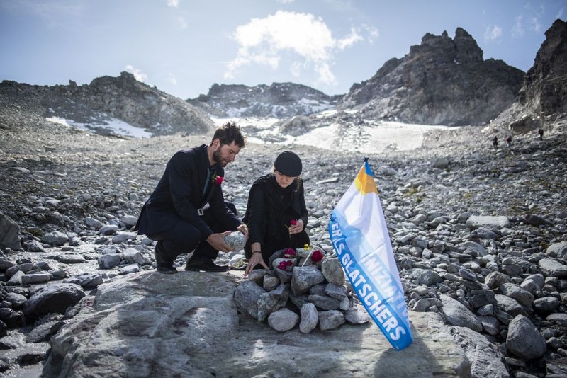 epa07861242 Activists put down stone and flowers during a commemoration for the dying glacier of Pizol mountain, in Wangs, Switzerland, 22 September 2019. Various organizations gathered to shine a light on climate change and melting glaciers. EPA-EFE/GIAN EHRENZELLER
