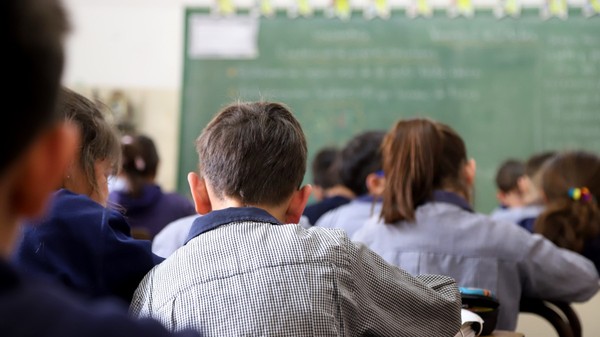 Elevi care stau în bănci, în clasă