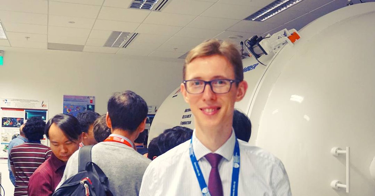 Cercetător român în Singapore. George Cristian Potrivitu Bocăneț într-un centru de cercetare, în cămașă, cu ecuson la gât