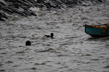 Un pescar înoată pentru a-și asigura barca în timp ce taifunul Goni se intensifică în Golful Manila FOTO: EPA-EFE/MARK R. CRISTINO
