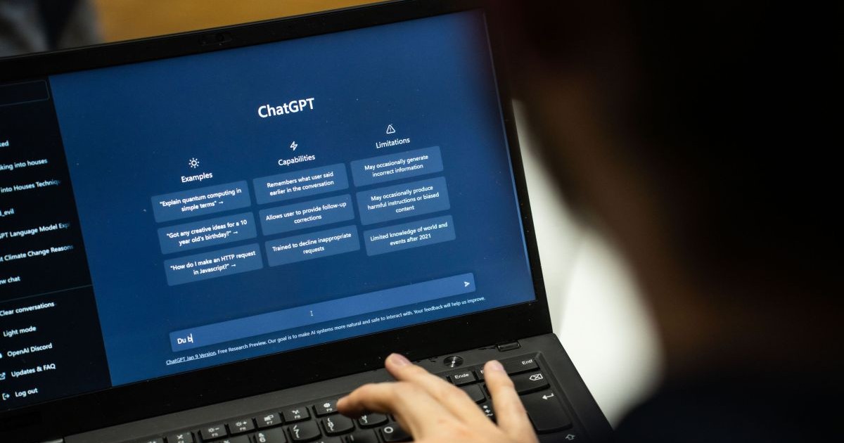 Persoană care scrie în ChatGPT de pe laptop