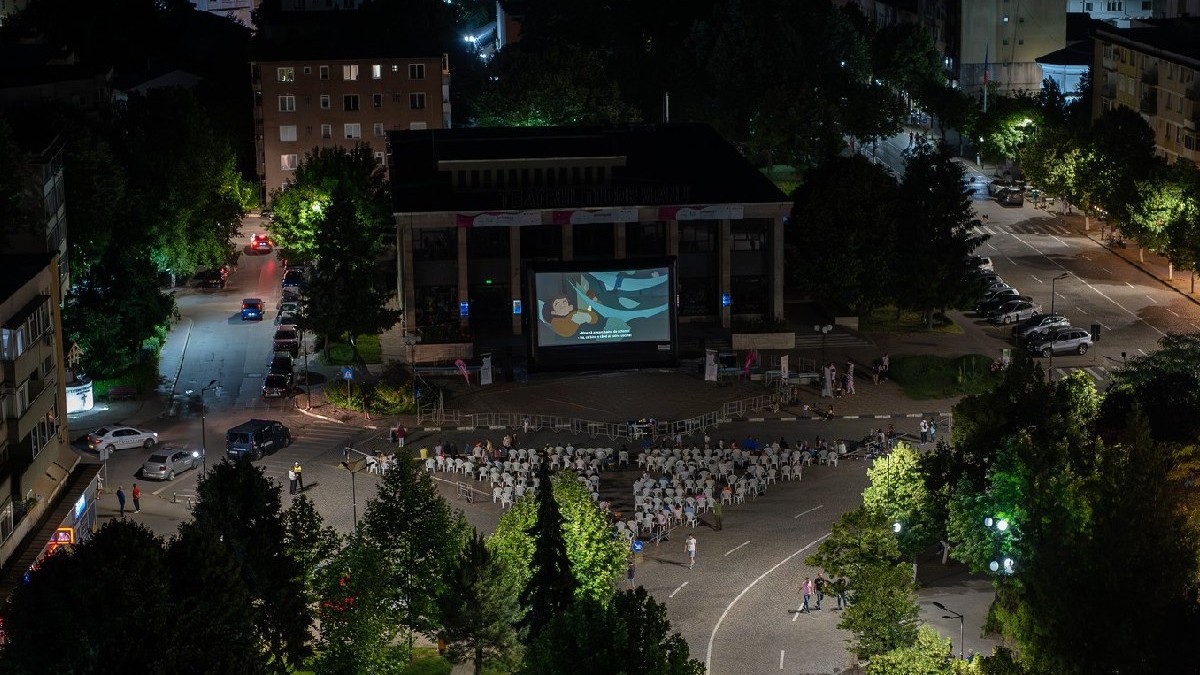 Mai mulți oameni urmăresc un film, la un cinematograf în aer liber din Giurgiu
