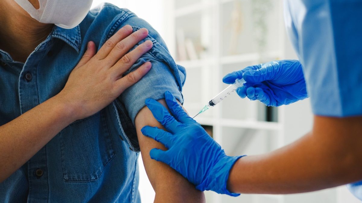medic care administrează un vaccin în brațul unui pacient