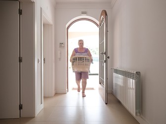 Mili aduce hainele și prosoapele spălate și călcate
