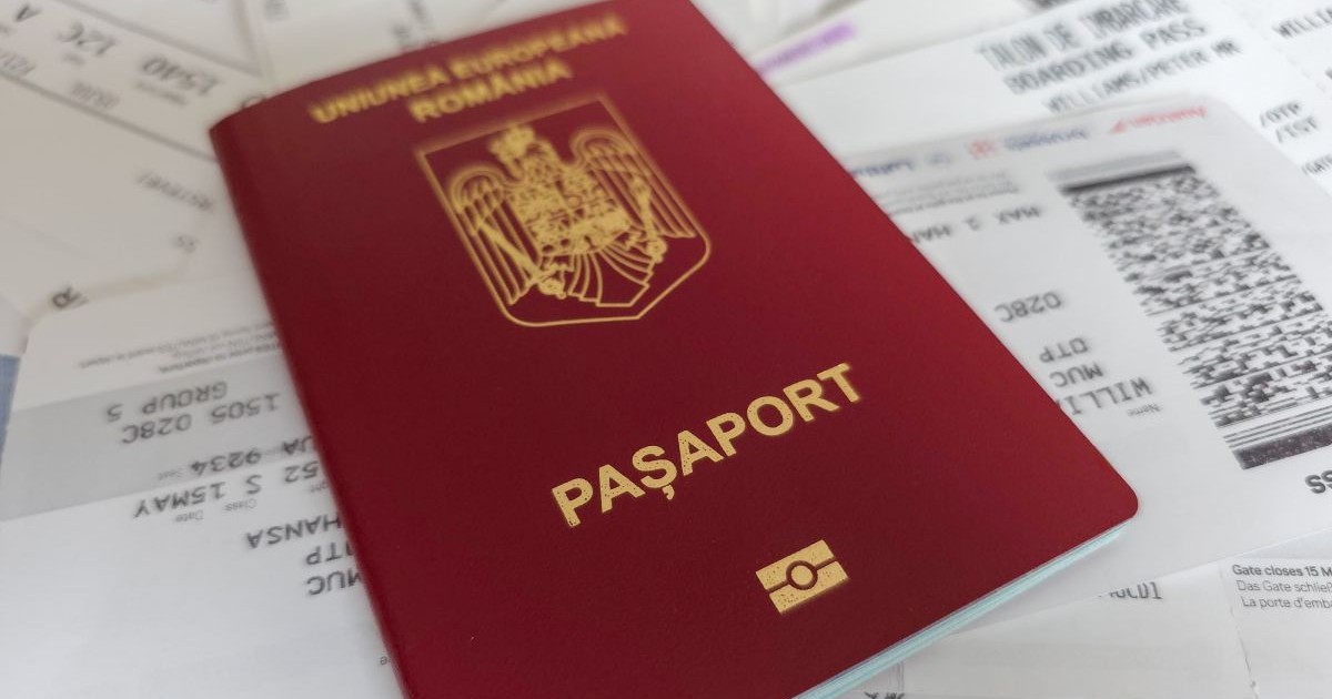 Pașaport românesc, de culoare maro, peste multe cărți de îmbarcare