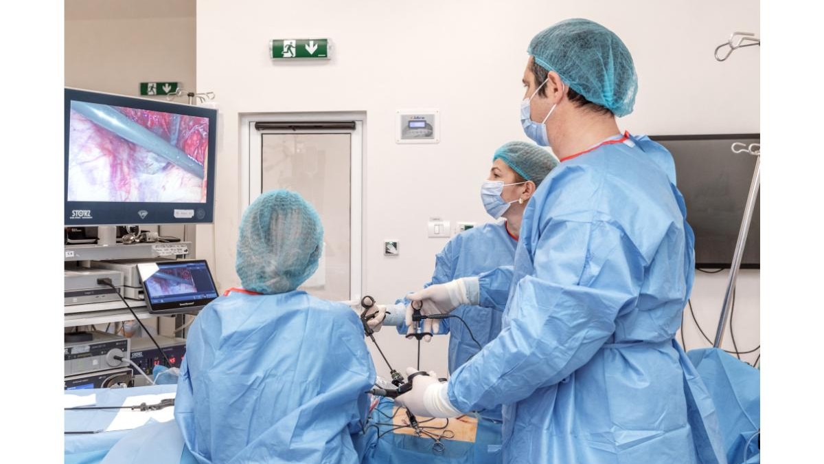Regina Maria - imagine cu 3 dotori uitandu-se la ecografia pacientului aflat pe pat