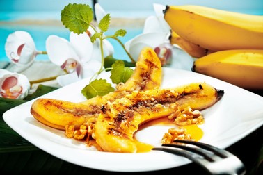 13385404 - delicious golden brown grilled banana and walnut dessert served on a white platter