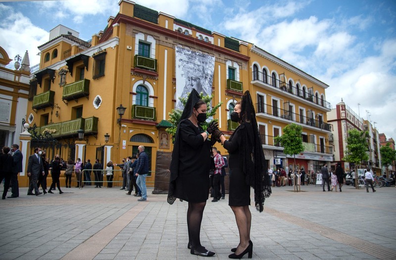 Două femei îmbrăcate în haine tradiționale pentru parada care, de obicei, este organizată în Joia Mare, în orașul spaniol Sevilla | Foto: Profimedia