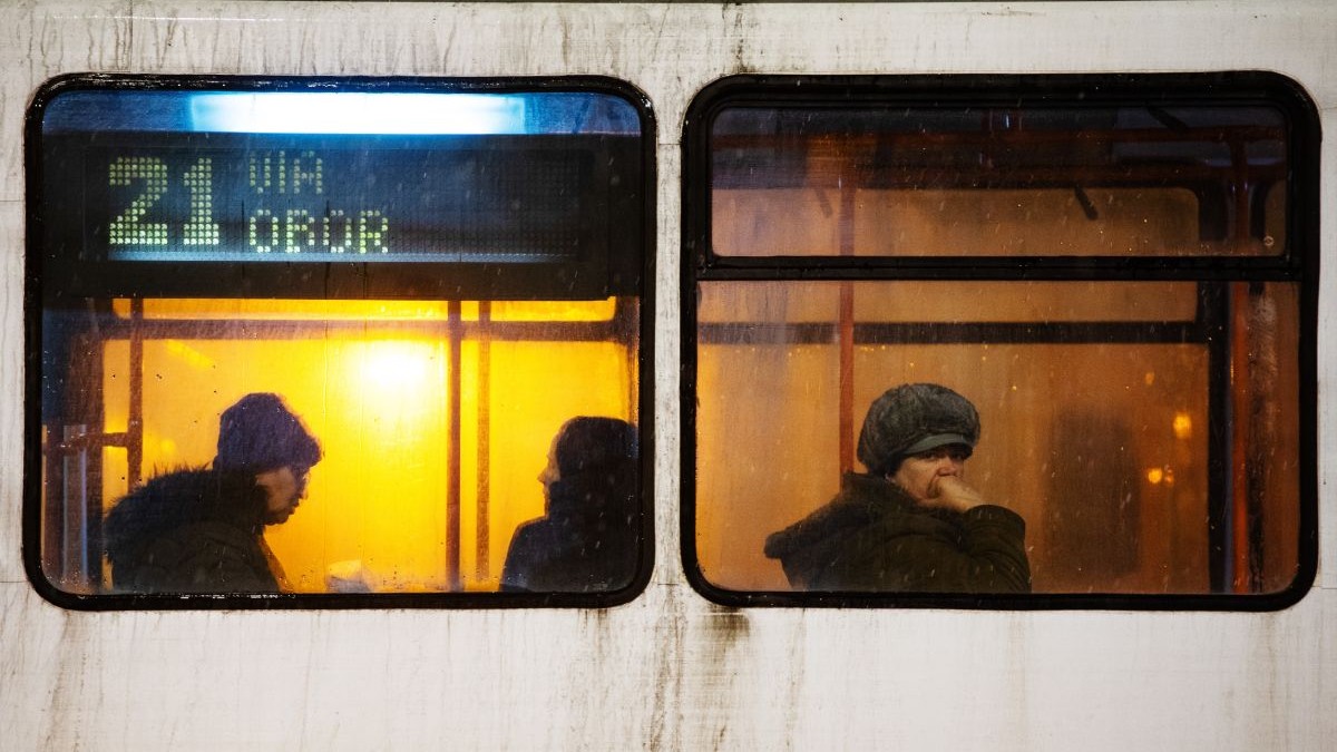 Oameni îmbrăcați gros în tramvaiul 21 din București, pe vreme rea