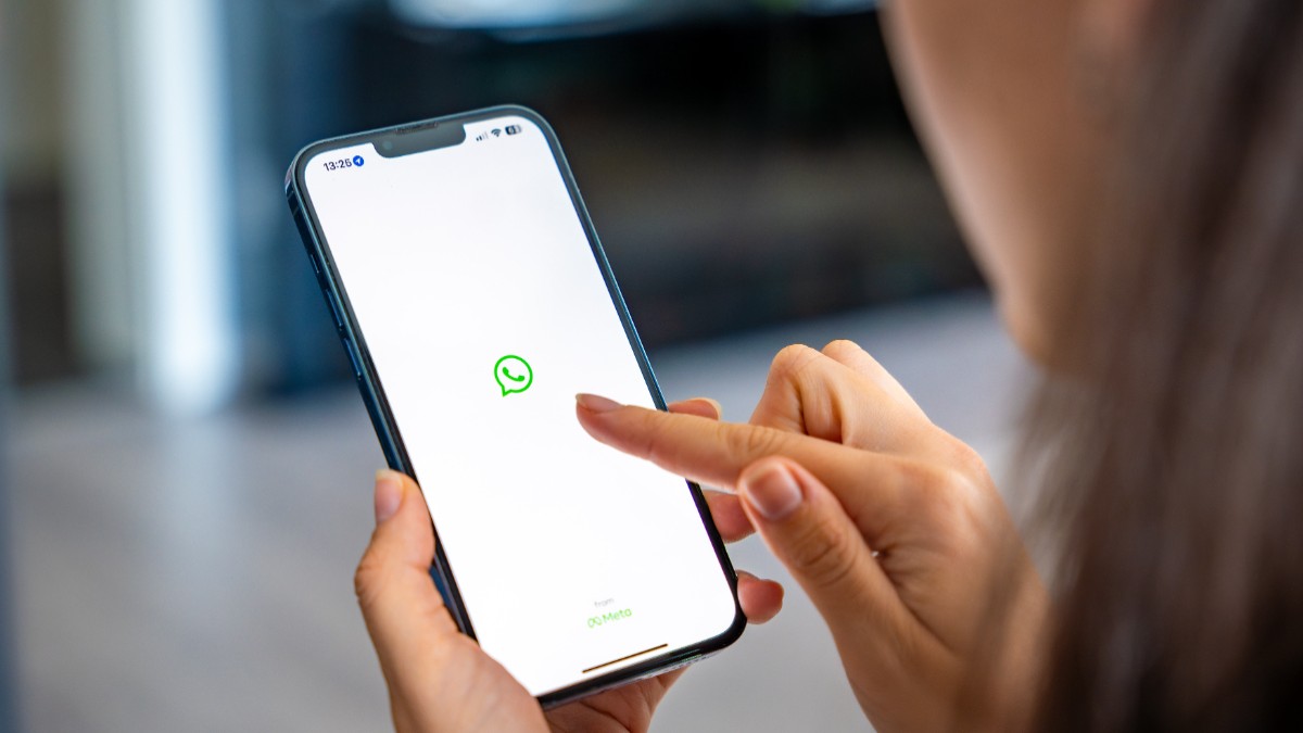 O femeie care accesează aplicația WhatsApp pe telefon