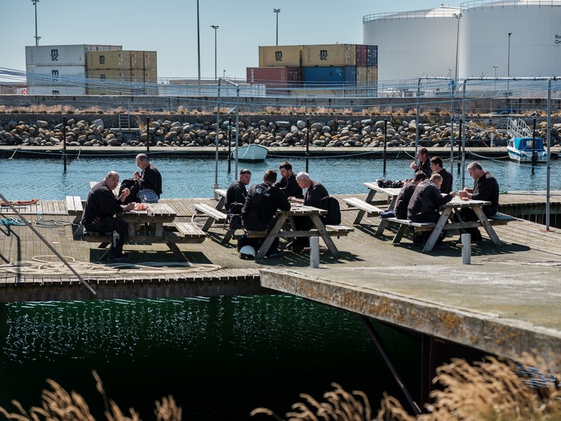 Electricieni români mănâncă în pauza de prânz pe un ponton din șantierul naval Karstensens. Skagen, Danemarca