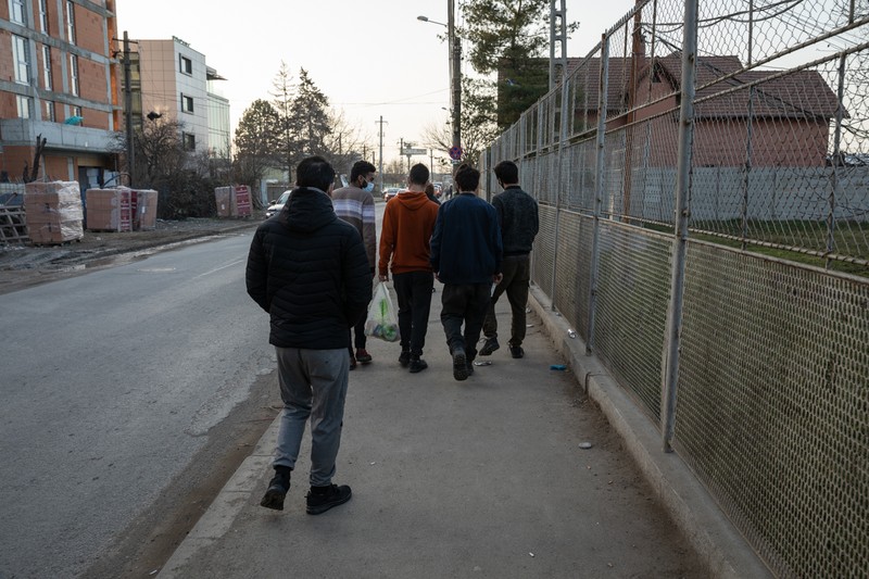 Câțiva migranți ies de la Centrul Regional de Proceduri şi Cazare a Solicitanților de Azil – Timișoara. Centrele sunt în regim deschis, dar dacă lipsesc mai mult de trei zile, pierd dreptul de a sta acolo.