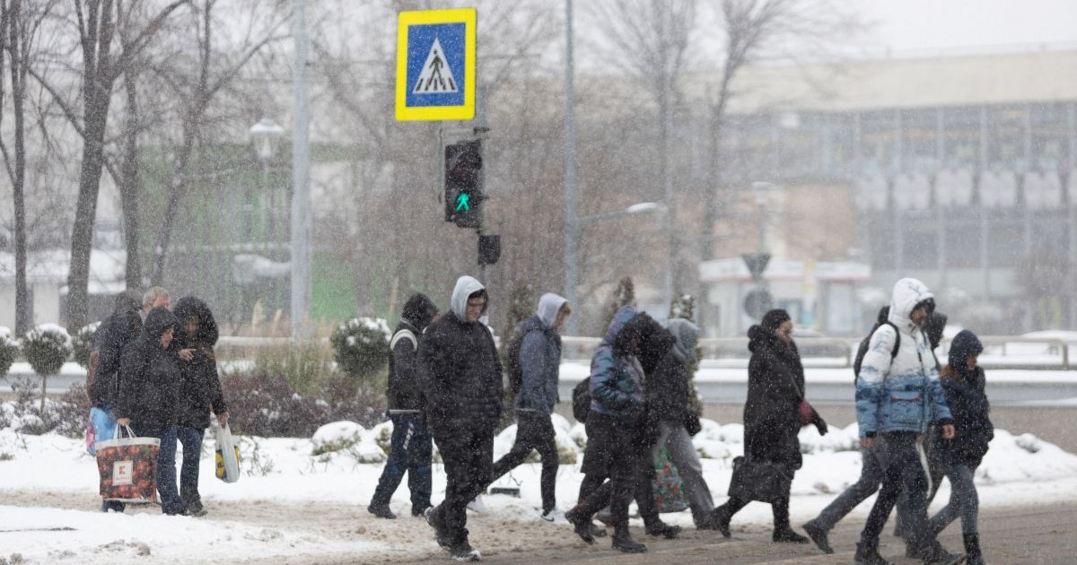 Mai multe persoane traverseaza o strada in timpul unei ninsori, in Bucuresti, luni, 17 februarie 2025.