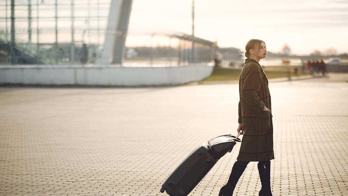 Femeie in aeroport trage un troller