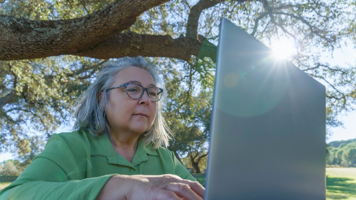 femeie în vârsta care lucrează pe laptop