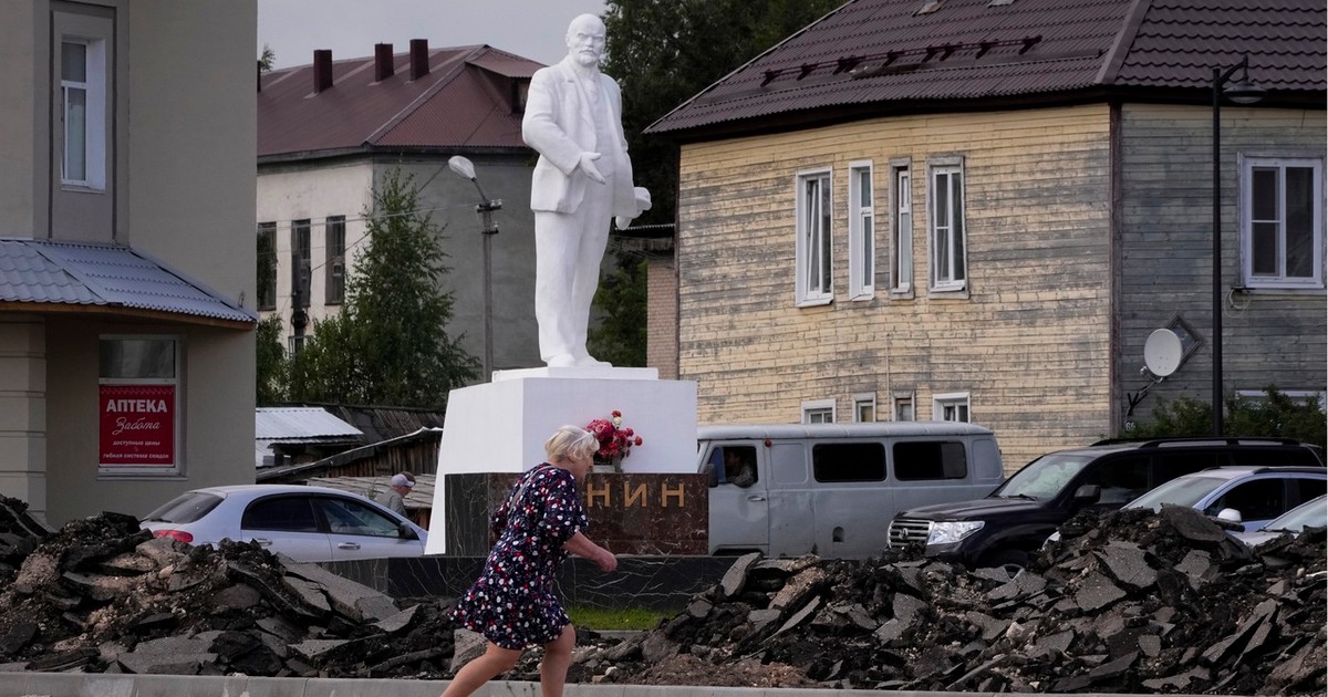 Imagine din Kargopol, regiunea Arhanghelsk. Iunie 2024 - o femeie merge prin fața statuii lui Lenin Foto: Profimedia
