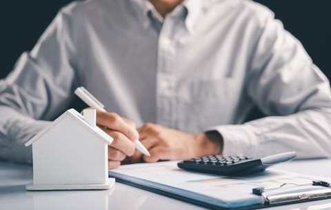 Un bărbat calculează taxele și impozitele pentru locuințe