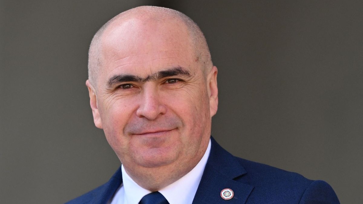 Ilie Bolojan, președintele interimar al României, în prim plan, îmbrăcat în costum, cravată și cămașă albă