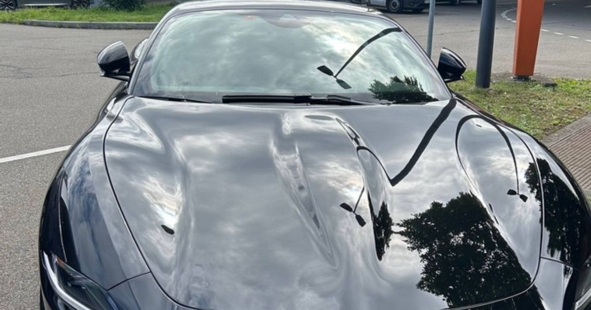 Un Ferarri Roma negru, cu vopsea strălucitoare, oprit pe sosea