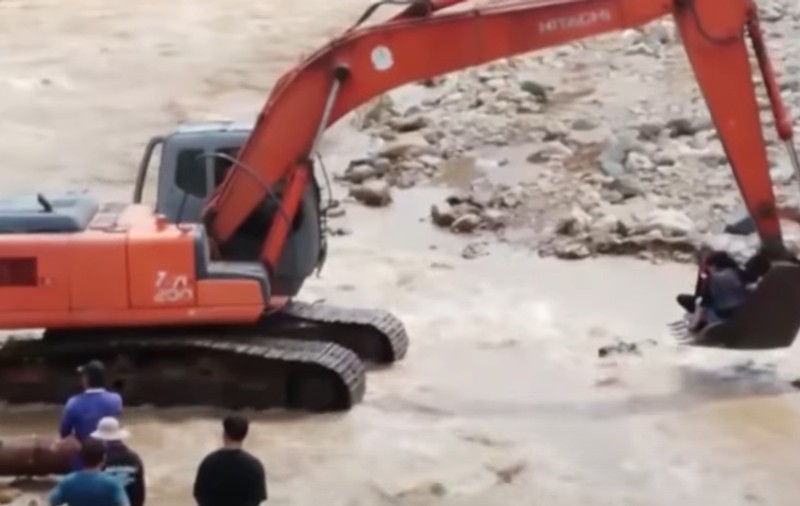 O femeie în travaliu a trecut râul umflat în cupa excavatorului, după ce un pod s-a prăbușit în urma inundațiilor, în Thailanda | VIDEO