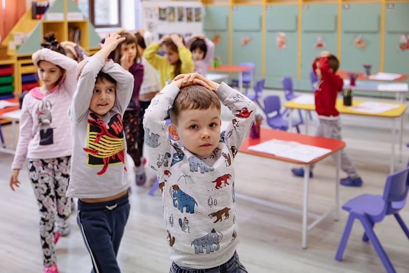 Copiii ies ordonat din clasă, urmând indicațiile educatoarei